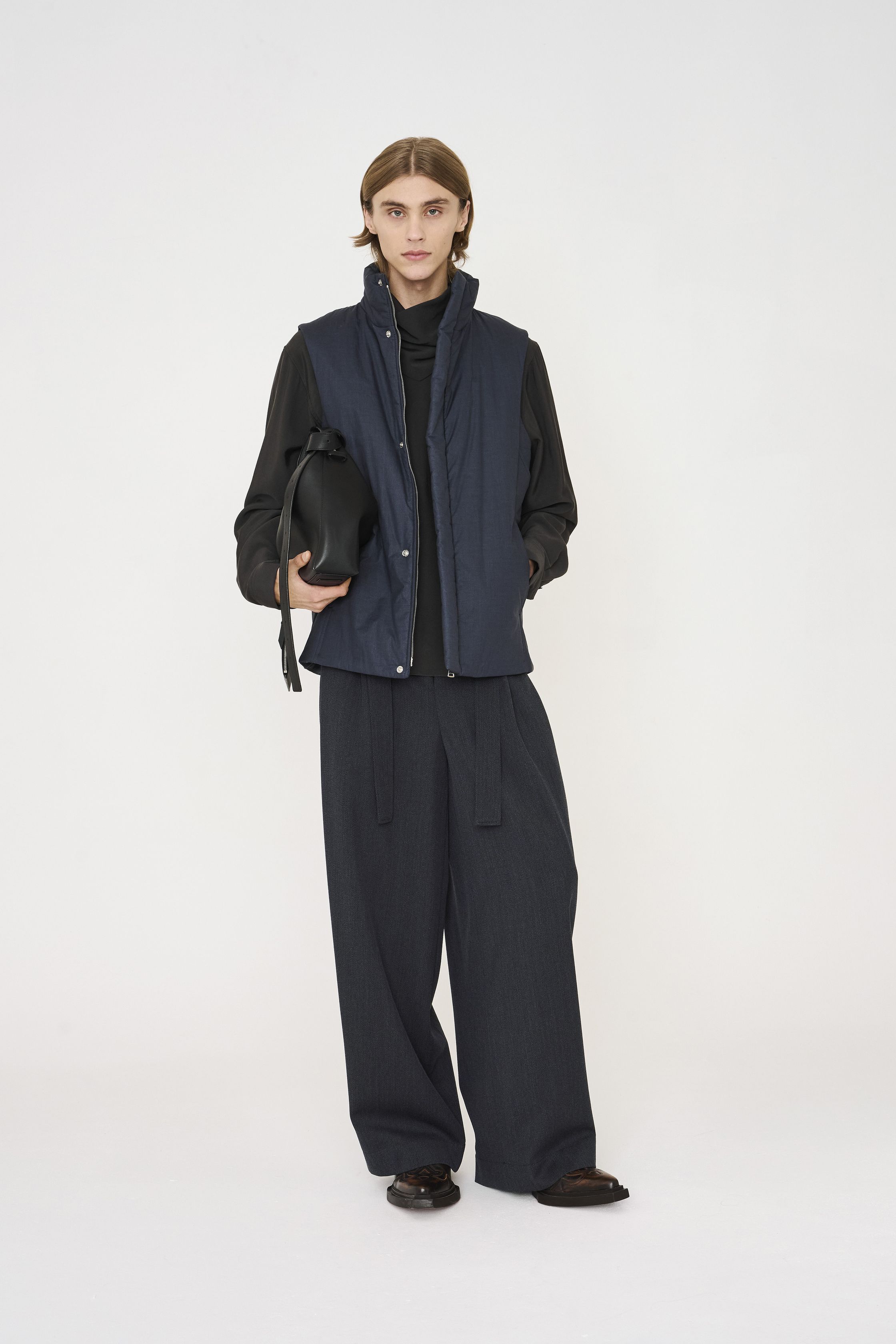Nehera 26FW 延续品牌一贯的理性与克制，将中欧现代主义精神转化为高度可穿的当代衣橱。系列以灰、米、深蓝与低饱和卡其为主轴，宽松直线廓形与柔软面料并行，强调身体与服装之间的自然距离。外套、短夹克与宽裤通过层次与比例建立秩序感，设计不追求视觉刺激，而是通过结构稳定性与材质质感传达一种冷静、内省的力量。这是一种拒绝时尚喧哗的“安静理性”，非常契合当下全球对长期主义与真实穿着价值的回归-顽石频道趋势研究